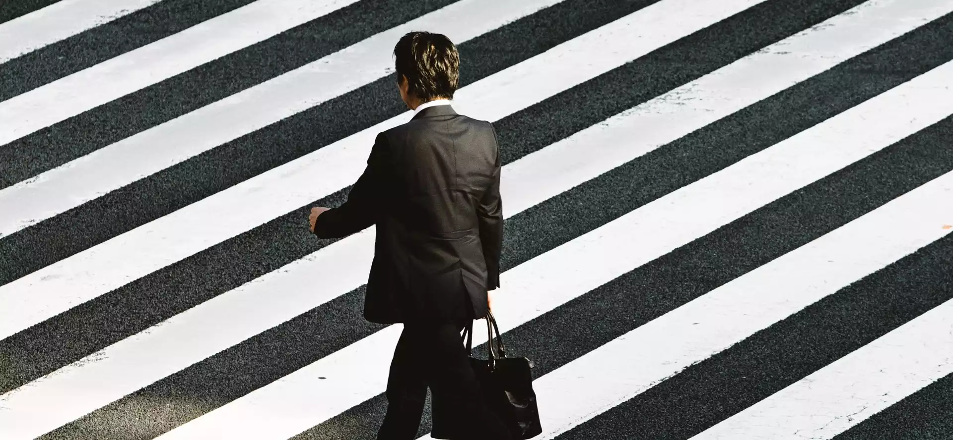 Homme portant un costume qui traverse un passage piéton à Tokyo